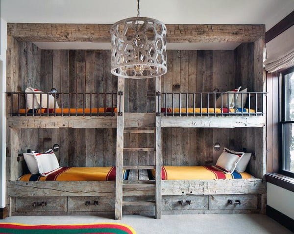 Rustic wooden bunk beds with colorful blankets and a geometric pendant light in a cozy bunk room