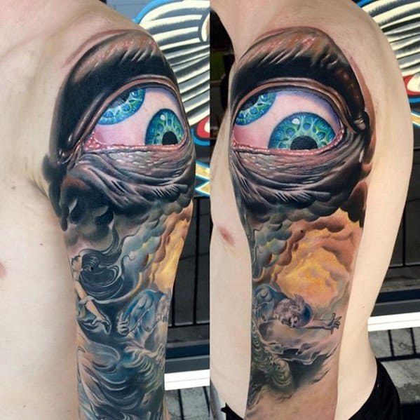 Surreal tattoo sleeve of a large blue eye above swirling clouds and divine figures in a dreamlike, celestial scene.