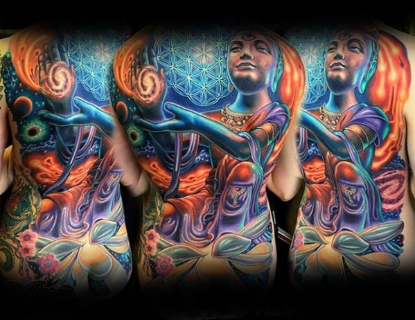 Vibrant full-back tattoo of a serene, divine figure surrounded by cosmic elements, glowing lotus flowers, and a sacred geometric background.