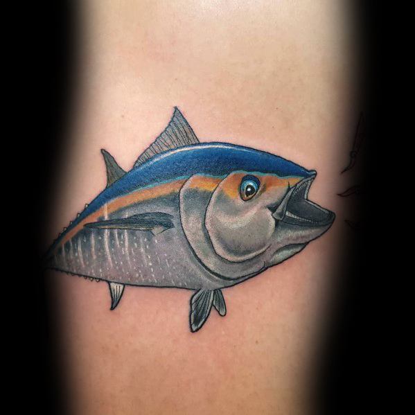 Realistic tuna fish tattoo on a man's skin, featuring vibrant blue and gold tones, fine shading, and intricate details for a lifelike ocean design.
