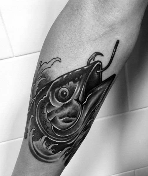 Black and grey tuna fish tattoo on a man's forearm, featuring bold shading, intricate details, and a fishing hook for a dynamic ocean-themed design.