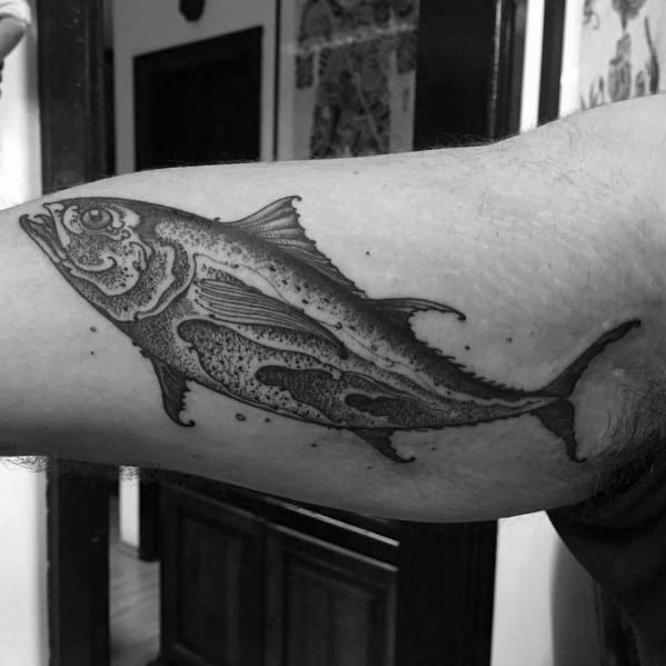 Detailed black and grey tuna fish tattoo on a man's arm, featuring fine linework, intricate shading, and a realistic ocean-inspired design.