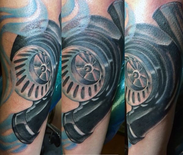 Close-up of a detailed black and grey tattoo of a mechanical part, likely a turbocharger, on an arm