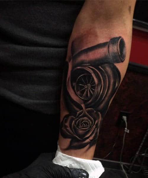 Forearm tattoo of a rose intertwined with a turbocharger, depicting a blend of nature and machinery in black ink