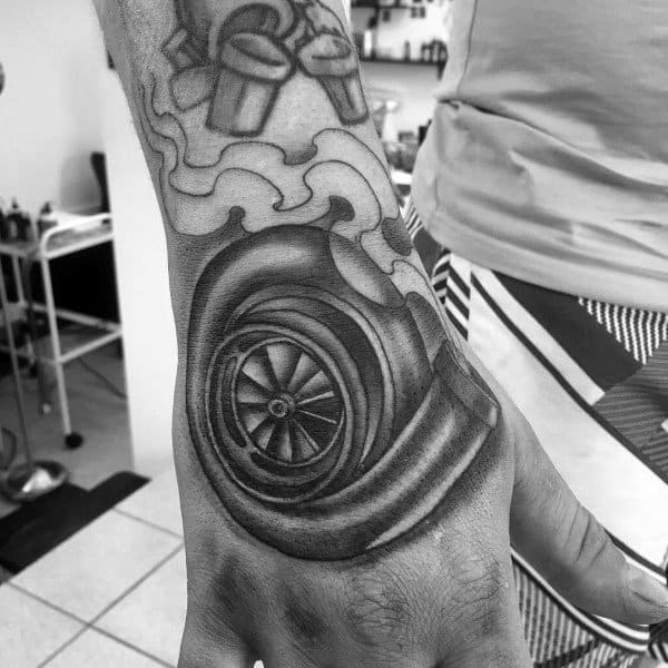 Realistic **turbocharger** tattoo on the hand with bold shading and smoke details, symbolizing speed, power, and a passion for high-performance engines.