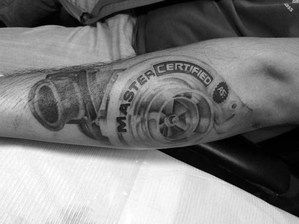 Realistic **turbocharger** tattoo on the forearm with **"Master Certified"** text and fine shading, symbolizing expertise, power, and passion for automotive performance.