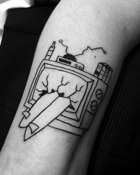 Black ink tattoo of a vintage TV with missiles bursting through the screen, surrounded by city buildings and antennas, symbolizing destruction and media influence.
