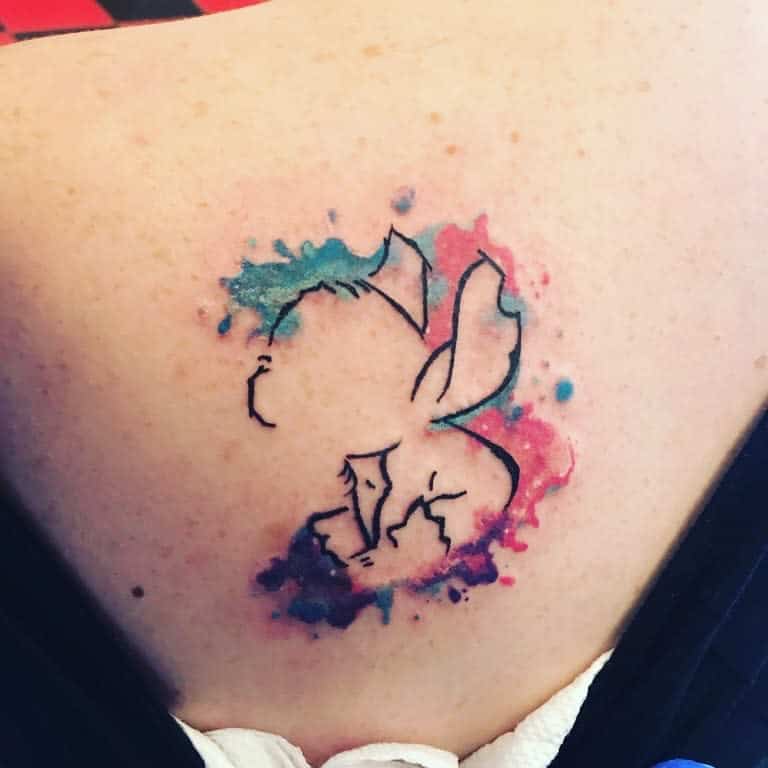 Outline tattoo of Angel from Lilo & Stitch with colorful watercolor splashes, on the back.