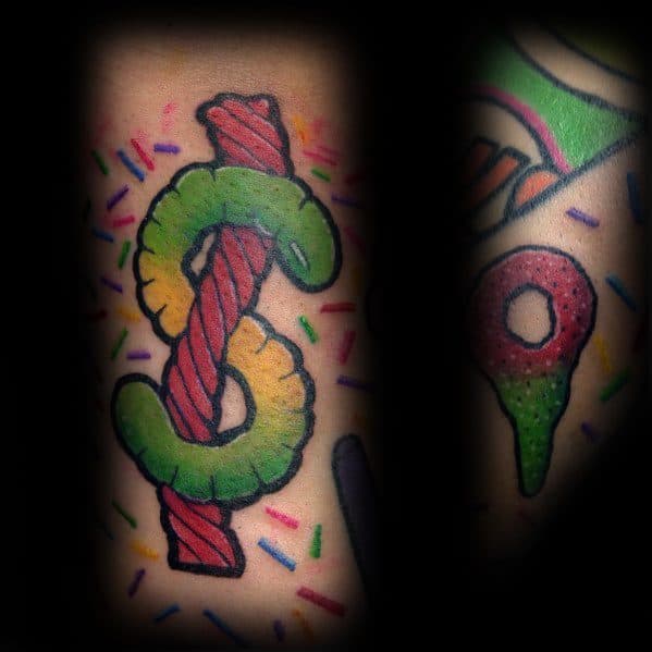 Colorful candy-themed tattoo featuring a dollar sign made from gummy and twisted licorice, surrounded by vibrant sprinkles for a playful touch.
