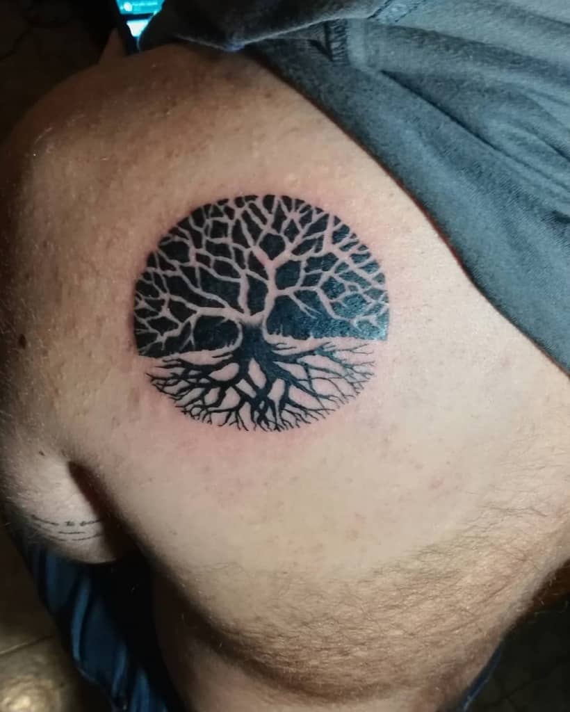 Minimalist Yggdrasil tattoo in a circular design, featuring intricate branches and roots, symbolizing balance, growth, and Norse mythology.
