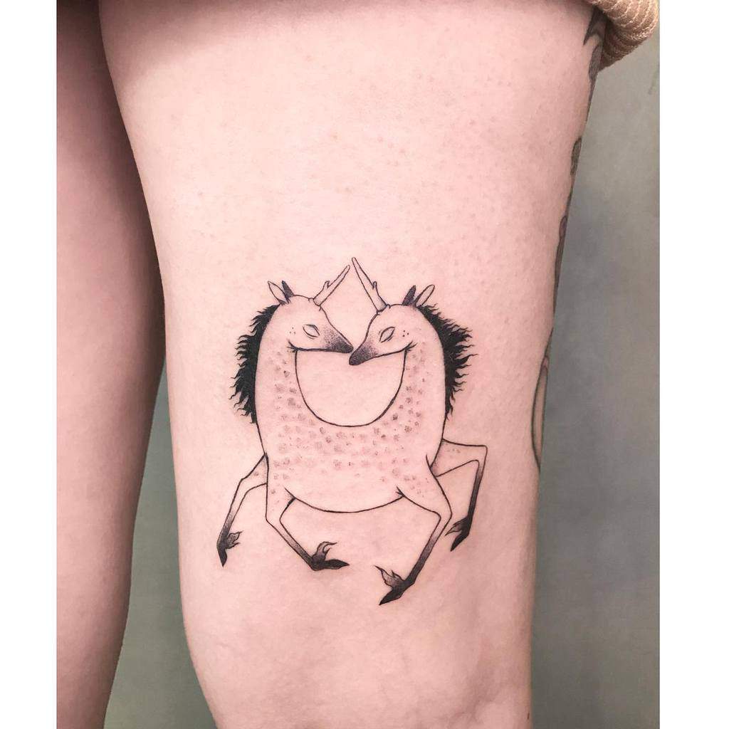 Unique black ink tattoo of two unicorns forming a circular shape with their bodies, touching horns in a surreal and minimalist design.