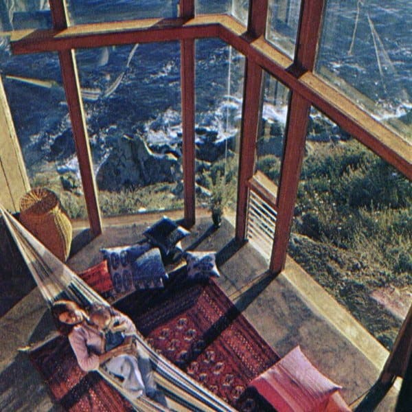 Hammock in a cozy corner with large glass windows overlooking a stunning ocean view.