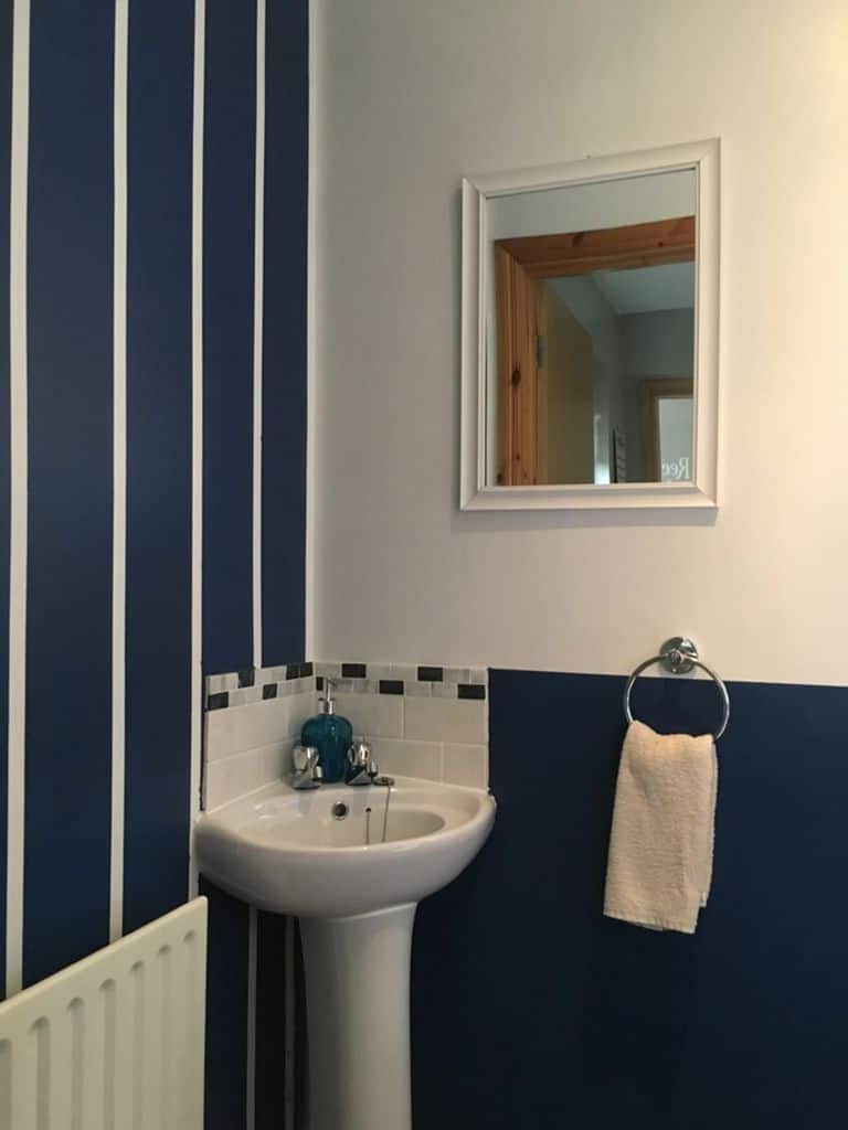 two tone blue and white bathroom with corner sink
