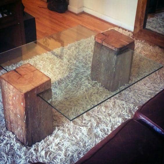 Glass coffee table with wooden block supports on a shag rug in a cozy living room