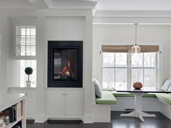 Cozy living room with a modern fireplace, white walls, and a window nook with green cushions