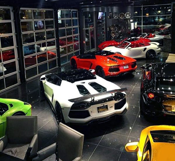 Ultra-luxury garage with exotic cars, glass doors, and sleek black tiles.