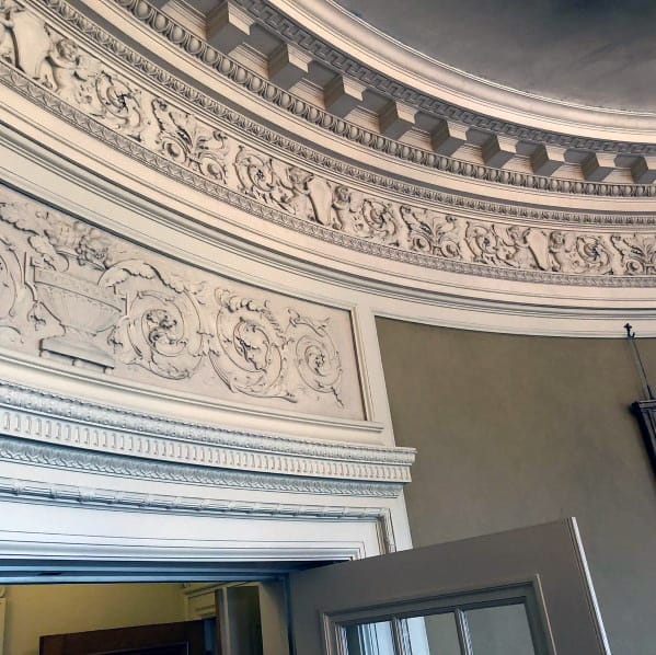 Ultra-detailed vintage crown molding with intricate floral and geometric patterns, enhancing the architectural elegance of the room