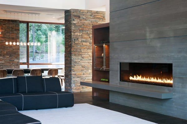 Modern living room with sleek linear fireplace, stone accent wall, and black furniture.