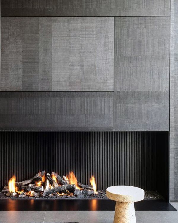 A luxurious, ultra-modern fireplace with textured black panels and a sleek firebox for a bold yet refined statement.