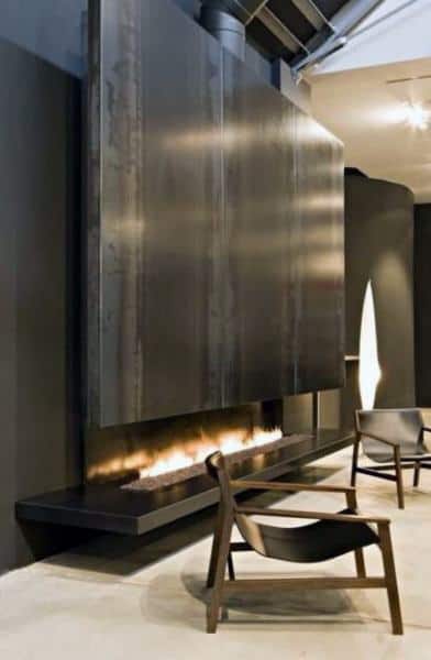 Ultra-modern gas fireplace with a sleek black metal panel above and a minimalist linear flame design.