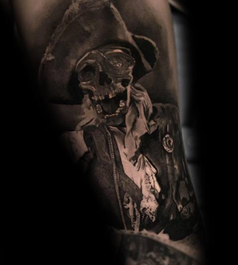 Black and gray realistic tattoo of One-Eyed Willy from *The Goonies*, featuring a detailed skull wearing a pirate hat and tattered clothing.