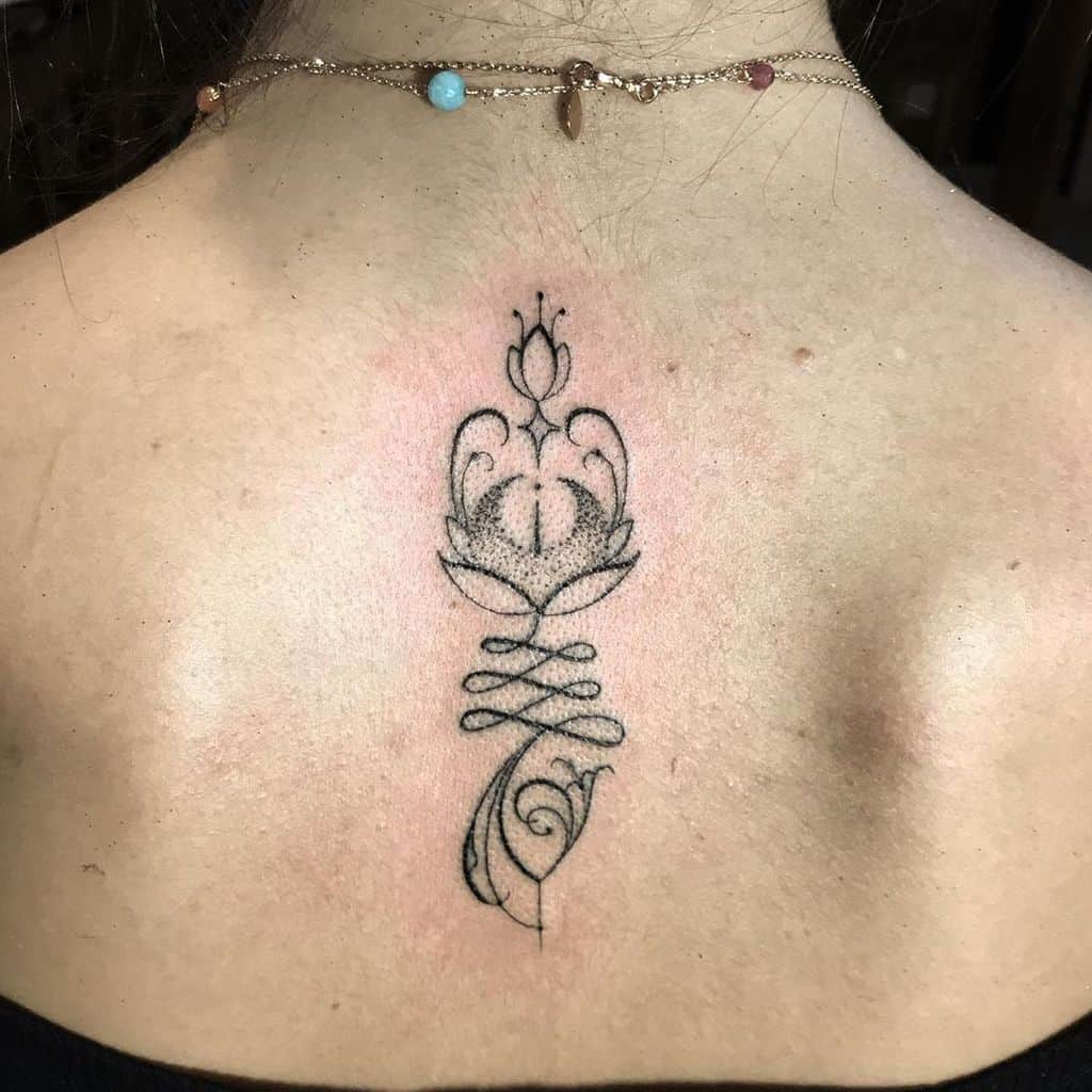 Unalome tattoo with an ornamental lotus on the upper back, symbolizing spiritual enlightenment, growth, and the journey toward inner peace.