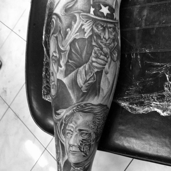 Detailed black and gray sleeve tattoo featuring Uncle Sam pointing, surrounded by smoke and layered portraits, blending realism and surreal elements.