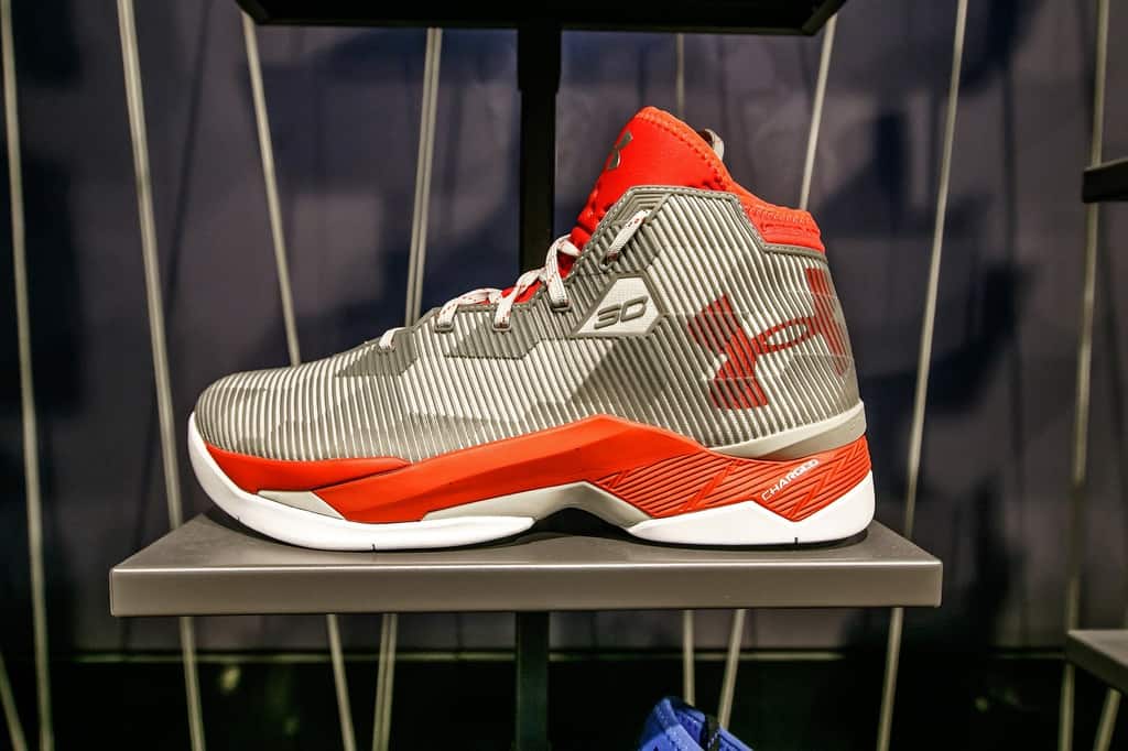 An orange and grey Under Armour basketball shoe.
