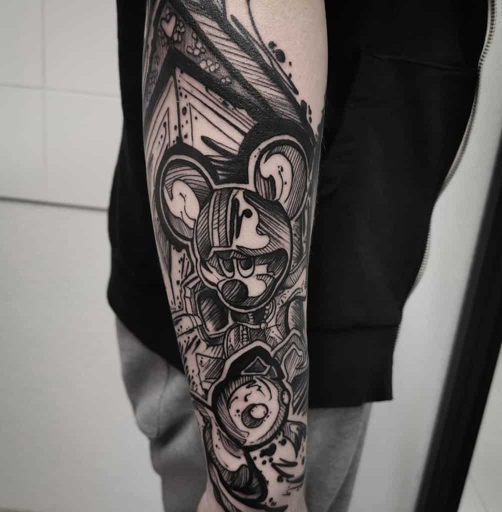 Bold black ink tattoo of King Mickey from Kingdom Hearts on the forearm, featuring heavy shading, dynamic linework, and abstract details.