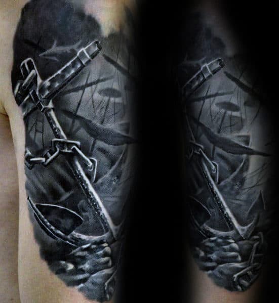 Black and grey tattoo of a coral-covered anchor with chains, surrounded by underwater scenery