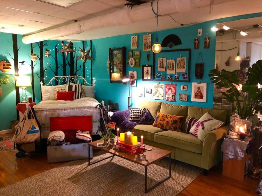 Eclectic bedroom with teal walls, cozy lounge area, and colorful decor details.