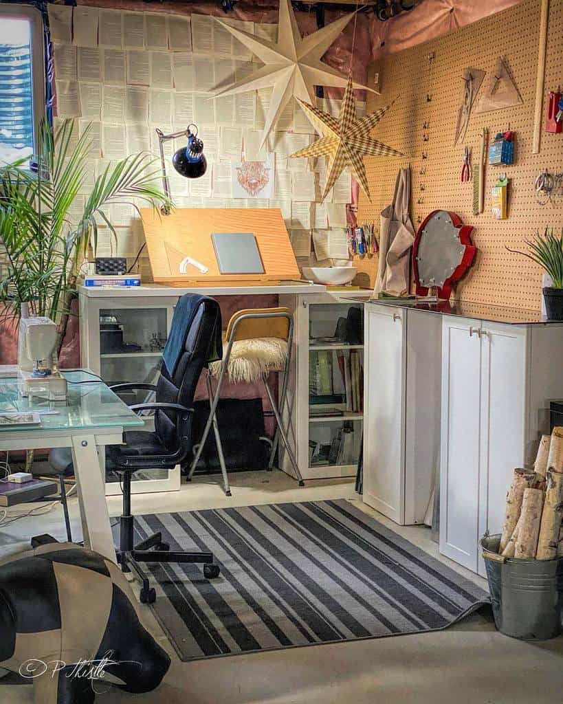 Creative home office with art supplies, pegboard storage, star decor, and books as wallpaper backdrop.