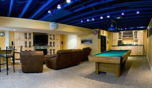 Basement with blue exposed ceiling, pool table, leather seating, and built-in kitchenette.