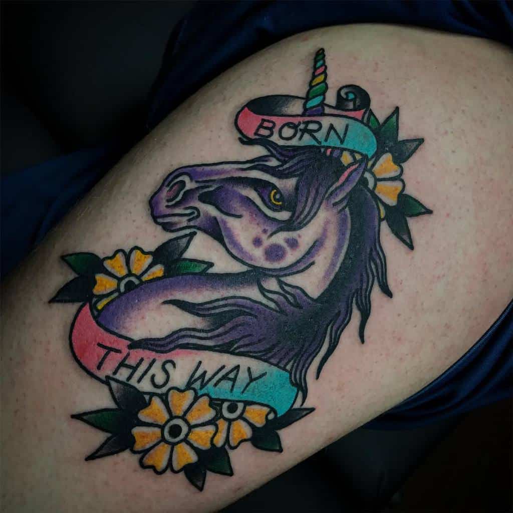 A colorful unicorn tattoo with the text "Born This Way" and floral accents