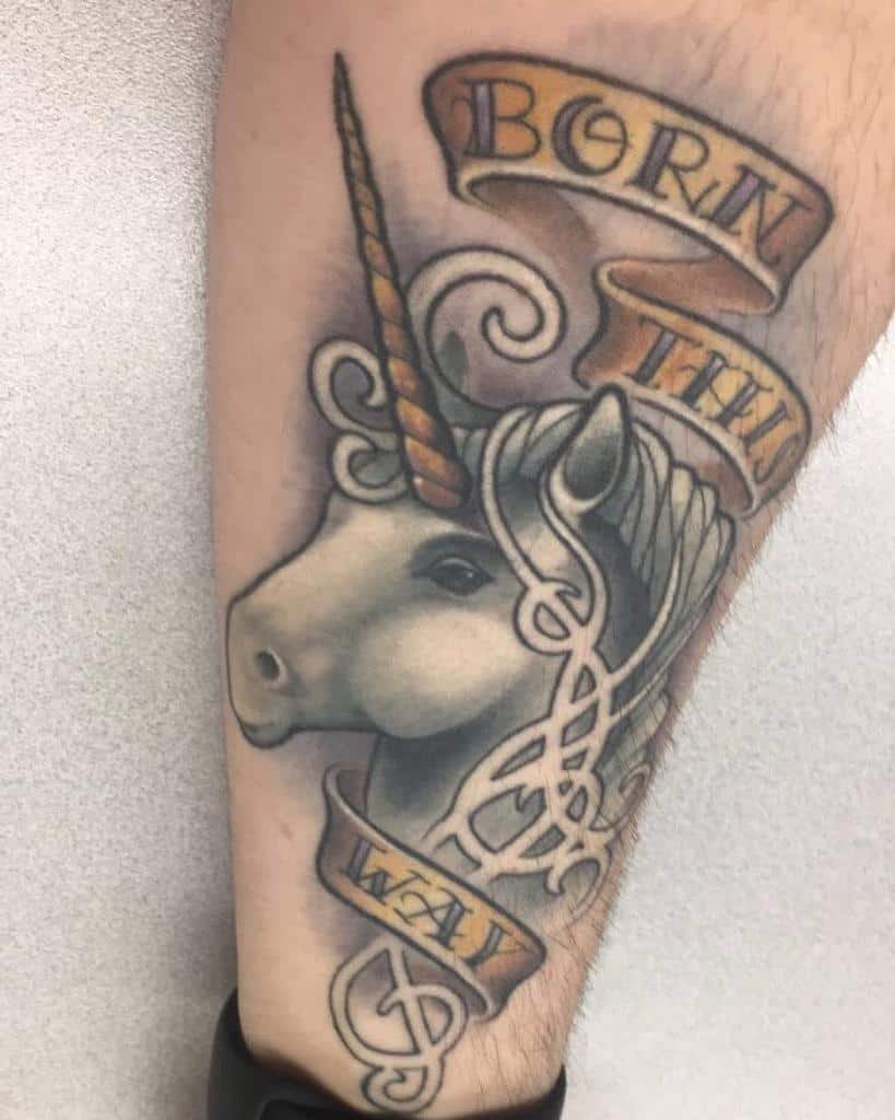 Unicorn tattoo with scrolls reading "Born This Way" on an arm