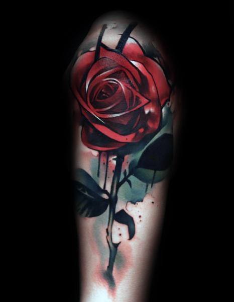A stunning tattoo of a realistic red rose with lush stems and leaves