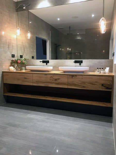 Large modern bathroom with floating wood vanity, double sinks, and pendant lighting.