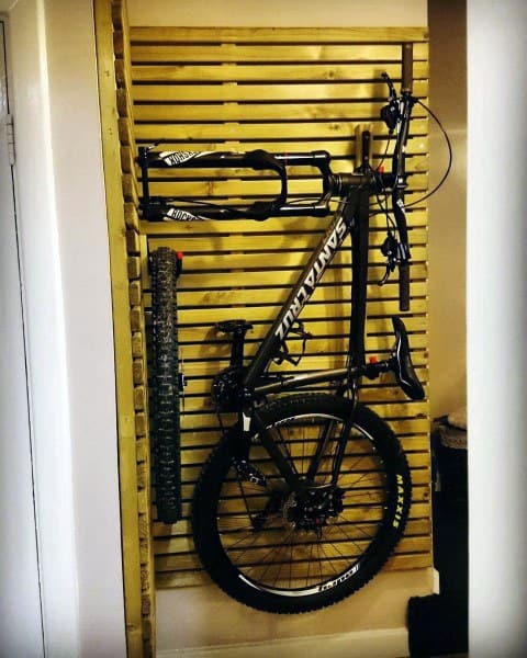 Compact vertical bike rack using a slatted wooden wall for sleek, space-saving storage.
