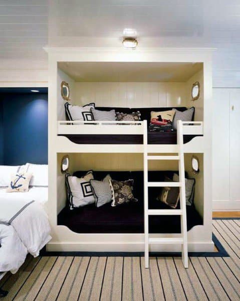 Nautical-themed bunk bed with ladder, blue wall, and striped carpet