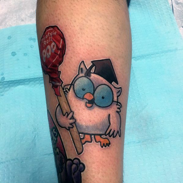 Tattoo of the classic Tootsie Pop owl wearing glasses and a graduation cap, holding a red lollipop in a playful and nostalgic design.