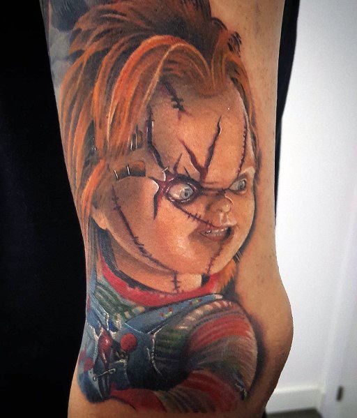 Realistic Chucky tattoo with detailed shading, featuring his stitched face, piercing blue eyes, and sinister expression for a bold horror-inspired design.