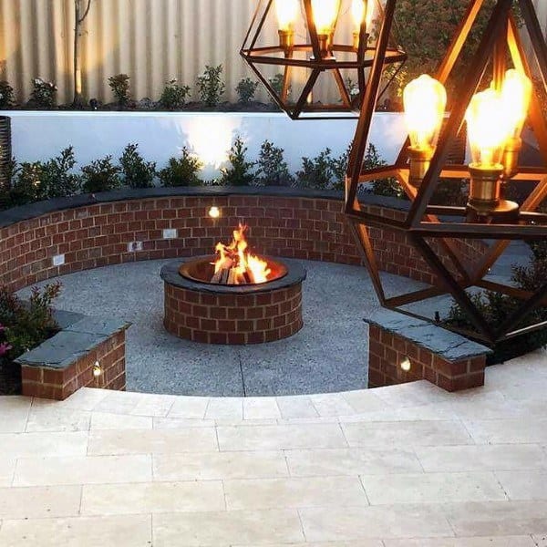 Circular brick fire pit with stylish hanging lights and cozy ambiance.