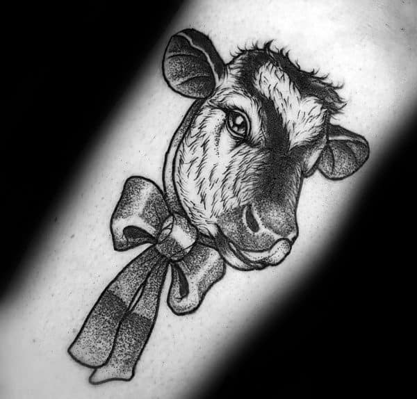 Dotwork tattoo of a cow's head with a detailed bow around its neck, combining realism with a soft decorative touch.