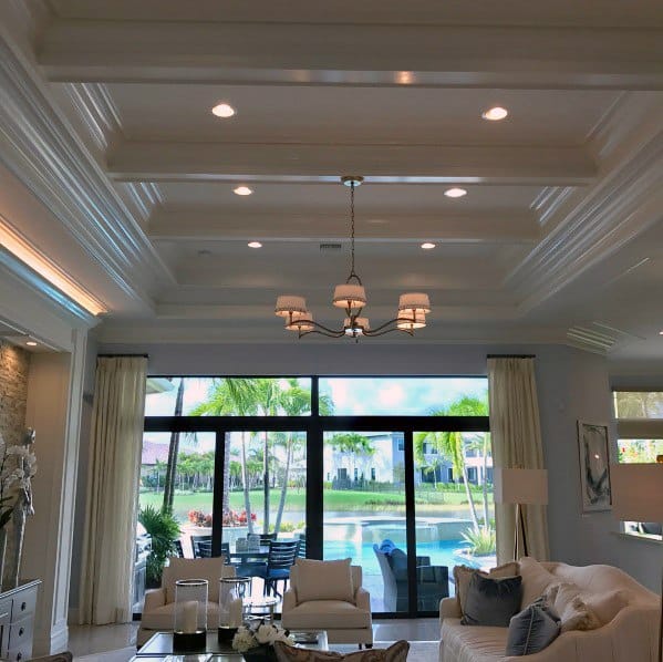 Spacious living room with unique crown molding lighting, accentuated by natural light and a beautiful outdoor view