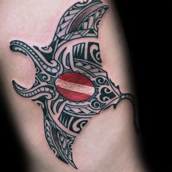 Tribal manta ray tattoo with intricate black patterns, featuring a red and white dive flag at its center, symbolizing ocean exploration.