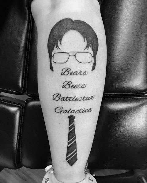 Minimalist black ink tattoo of Dwight Schrute's iconic hair, glasses, and tie, with the phrase "Bears. Beets. Battlestar Galactica." written in script.