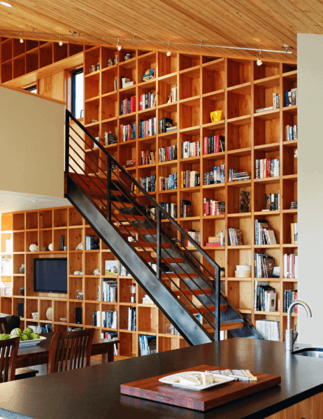 Modern living room with a sleek bookshelf and a metal staircase