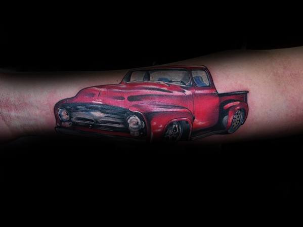 Realistic red vintage Ford pickup truck tattoo on forearm, featuring bold colors, intricate shading, and a classic nostalgic design.