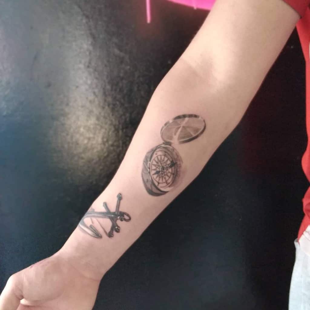 Forearm tattoo of a compass and an anchor on the wrist