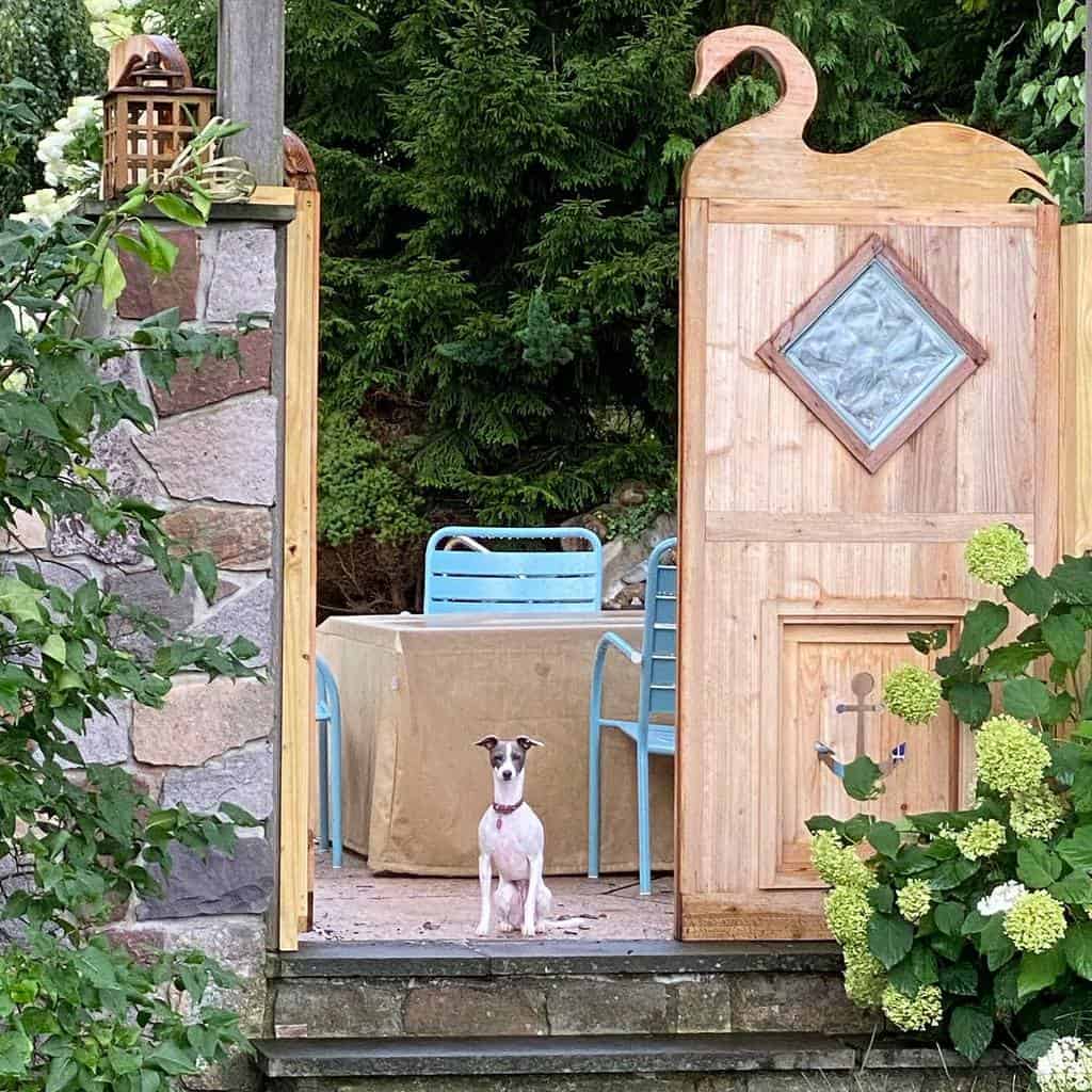 wood garden gate swan design backyard blue chairs dog